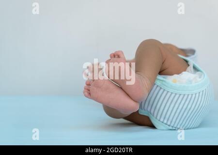 Foto der Füße eines 15 Tage alten Neugeborenen, der auf einer blauen Windel liegt. Stockfoto