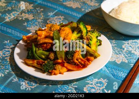 Chinesisches Huhn im Hunan-Stil mit gemischtem sautiertem Gemüse und weißem Reis Stockfoto