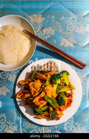 Chinesisches Huhn im Hunan-Stil mit gemischtem sautiertem Gemüse und weißem Reis Stockfoto