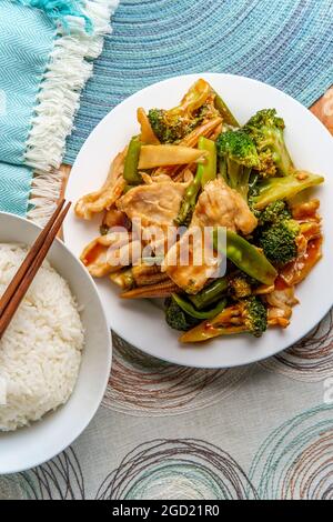 Chinesisches Huhn im Hunan-Stil mit gemischtem sautiertem Gemüse und weißem Reis Stockfoto