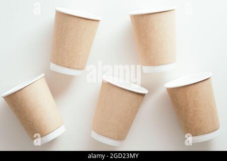 Pappbecher mit Kaffee zum Mitnehmen auf weißem Hintergrund. Flach liegend, Draufsicht. Stockfoto
