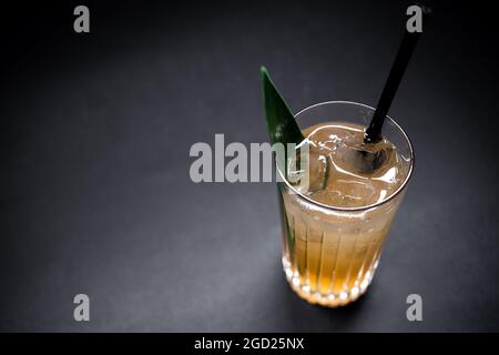 Erfrischendes Limonadengetränk oder Cocktail mit Eiswürfel in Glas auf schwarzem Hintergrund Stockfoto