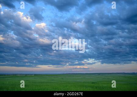 Stratocumulus Wolken über der Präriegrasfläche des Badlands National Park in South Dakota. Stockfoto