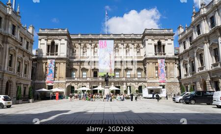 Die Royal Academy of Arts an einem sonnigen Tag mit Menschen, die draußen in der Sonne sitzen. London - 10. August 2021 Stockfoto