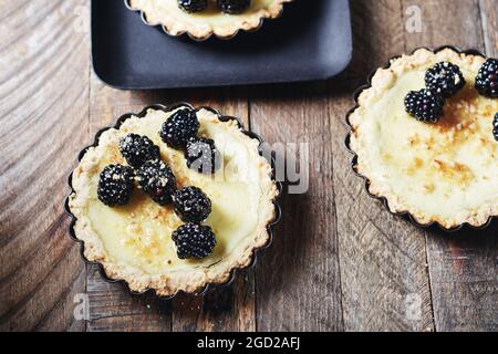 Frisch gebackene Brombeeren- und Vanillepudding-Torten. Stockfoto