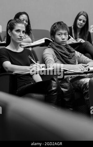 JOHANNESBURG, SÜDAFRIKA - 05. Jan 2021: Eine Graustufe von Studenten, die in einem Klassenzimmer sitzen, während sie dem Vortrag zuhören Stockfoto