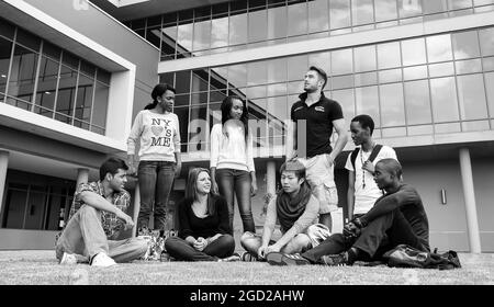 JOHANNESBURG, SÜDAFRIKA - 05. Jan 2021: Eine Graustufe von multirassischen Studenten, die auf dem Campus etwas diskutieren Stockfoto