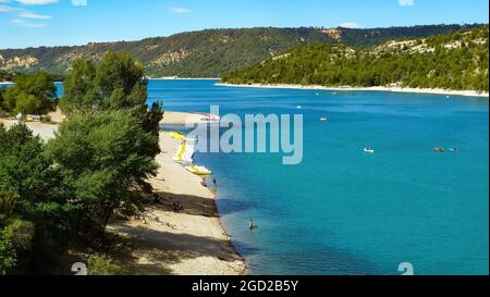 Blick auf den farbenfrohen See im Tal mit Kanus und Strand - Lac de sainte croix, Frankreich Stockfoto