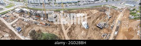 Bauarbeiten mit vielen Turmdrehkranen auf einer neuen Baustelle. Luftpanorama. Stockfoto