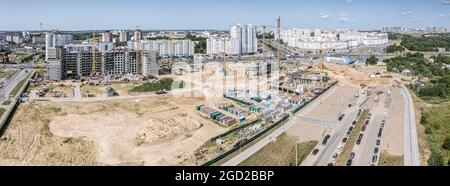 Große städtische Baustelle. Neue Hochhaus-Wohngebäude im Bau. Viele funktionierende Turmdrehkrane. Luftpanorama. Stockfoto