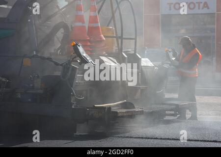 Tula, Russland - 16. Mai 2021: Asphaltprozess, Asphaltfertiger-Maschine während Straßenbauarbeiten, Arbeiten auf der neuen Straßenbaustelle, p Stockfoto