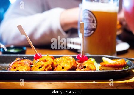 Nahaufnahme von Craft Beer in einem riesigen Becher mit Jubel der Leute, die mit Mocktails-Cocktails auf den Becher treffen, um Geselligkeit zu feiern, während sie sich entspannen Stockfoto