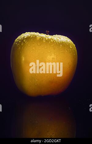 apfel mit Wassertropfen auf schwarzem Hintergrund Stockfoto