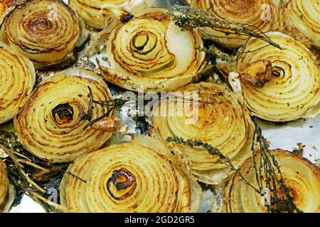 Gegrillte karamalisierte weiße Zwiebeln mit Kräutern auf einem Metalltablett Stockfoto