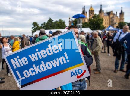 Schwerin, Deutschland. August 2021. Vor dem Schweriner Schloss steht ein AfD-Unterstützer mit einem Plakat mit der Aufschrift "nie wieder gesperrt" zu Beginn der Wahlkampftour der AfD. Die Partei kämpft mit dem Slogan "Deutschland. Aber normal.“ in den Wahlkampf. Quelle: Jens Büttner/dpa-Zentralbild/dpa/Alamy Live News Stockfoto