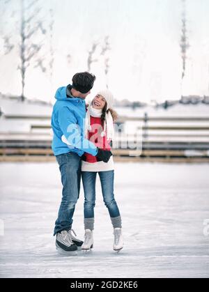 Eislaufen Winteraktivitäten Paar in der Liebe mit Spaß zu lernen, Eiskunstlauf auf der Eisbahn mit Verleih Schlittschuhe. Junge Skater romantisch im Freien Stockfoto