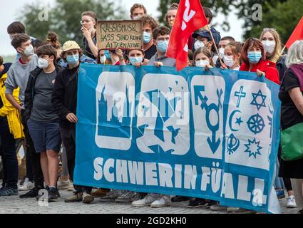 Schwerin, Deutschland. August 2021. Gegendemonstranten protestieren gegen den Start der AfD-Wahlkampftour unter anderem mit einem Transparent mit der Aufschrift "Schwerin für alle". In den jüngsten Wählerumfragen lag die AfD bei zehn bis elf Prozent. Quelle: Jens Büttner/dpa-Zentralbild/dpa/Alamy Live News Stockfoto