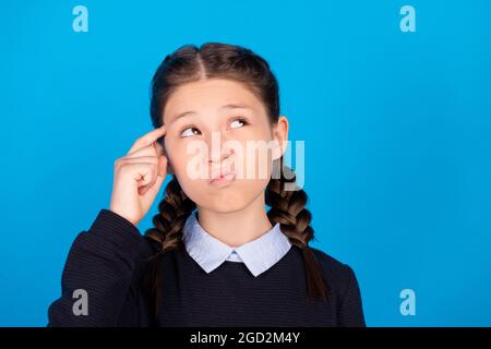 Foto von gesinnten jungen nachdenklichen Mädchen suchen leeren Raum Idee Stellen Sie sich isoliert auf blauem Hintergrund. Stockfoto