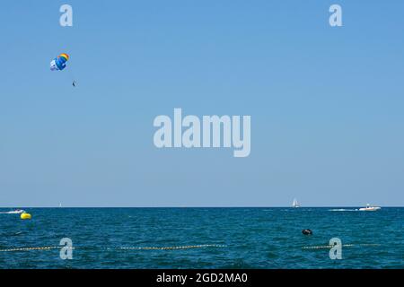 Ein Parascender oder Parasailer und ein Schnellboot vor der Adriaküste im Juli nördlich von Novigrad, Istrien, Kroatien Stockfoto
