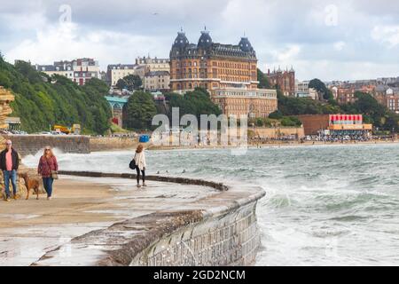 Wellen schlagen gegen die Verteidigung des Meeres mit dem Grand Hotel im Hintergrund in Scarborough Yorkshire Stockfoto