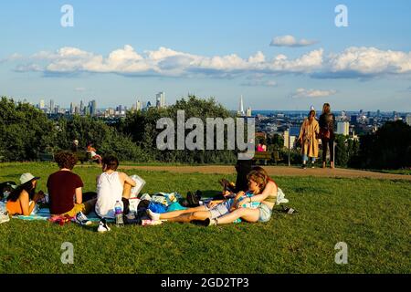 London, 10.. August 2021. Wetter in Großbritannien: Ein warmer, klarer Sonnenuntergang über London mit jungen Menschen, die sich am Parliament Hill, Hampstead Heath, bei Sonnenuntergang am Tag Der A Level Ergebnisse im Jahr 2021 versammeln. Stockfoto