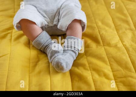 Kleine Füße eines Neugeborenen in Socken. Der erste Monat des Lebens eines Babys Stockfoto