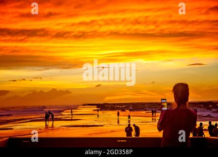 Eine Frau fotografiert am Pensacola Beach mit ihrem Mobiltelefon, während die Wellen des „Michael“-Flukes den Golf am 9. Oktober 2018 in Pensacola, Florida, aufwühlen. Stockfoto