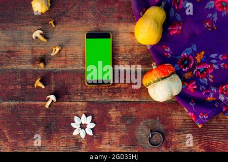 Herbstrahmen Zusammensetzung und Layout aus bunten Kürbissen und gelben Smartphone im Alter von alten antiquae Hintergrund Draufsicht, flach legen und kopieren Raum Har Stockfoto