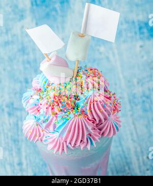 Blauer und rosafarbener Milchshake mit Marshallows auf blauem Hintergrund. Stockfoto