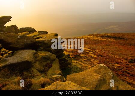 Riesige Felsformationen entlang des Wanderweges um den Ladybower Stausee im Nebel bei Sonnenuntergang, Peak District, Derbyshire, England Stockfoto