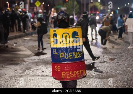 Bogota, Kolumbien, 09/08/2021, Demonstranten, die Schilde aus Holz und Metall verwendeten, um Wasser- und Tränengasbehälter zu bedecken, die von einem bewaffneten Lastwagen der kolumbianischen Bereitschaftspolizei während der Anti-Regierung geschossen wurden, was zu Zusammenstößen zwischen Demonstranten und der kolumbianischen Bereitschaftspolizei (ESMAD) inmitten der Räumung von Demonstranten führte, die während der letzten 3 in den Tibabuyes lagerten Monatelange regierungsfeindliche Proteste im Norden Bogotas, Kolumbien Stockfoto