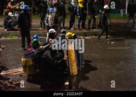 Bogota, Kolumbien, 09/08/2021, Demonstranten, die Schilde aus Holz und Metall verwendeten, um Wasser- und Tränengasbehälter zu bedecken, die von einem bewaffneten Lastwagen der kolumbianischen Bereitschaftspolizei während der Anti-Regierung geschossen wurden, was zu Zusammenstößen zwischen Demonstranten und der kolumbianischen Bereitschaftspolizei (ESMAD) inmitten der Räumung von Demonstranten führte, die während der letzten 3 in den Tibabuyes lagerten Monatelange regierungsfeindliche Proteste im Norden Bogotas, Kolumbien Stockfoto