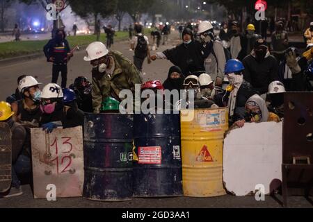 Bogota, Kolumbien, 09/08/2021, Demonstranten, die Schilde aus Holz und Metall verwendeten, um Wasser- und Tränengasbehälter zu bedecken, die von einem bewaffneten Lastwagen der kolumbianischen Bereitschaftspolizei während der Anti-Regierung geschossen wurden, was zu Zusammenstößen zwischen Demonstranten und der kolumbianischen Bereitschaftspolizei (ESMAD) inmitten der Räumung von Demonstranten führte, die während der letzten 3 in den Tibabuyes lagerten Monatelange regierungsfeindliche Proteste im Norden Bogotas, Kolumbien Stockfoto