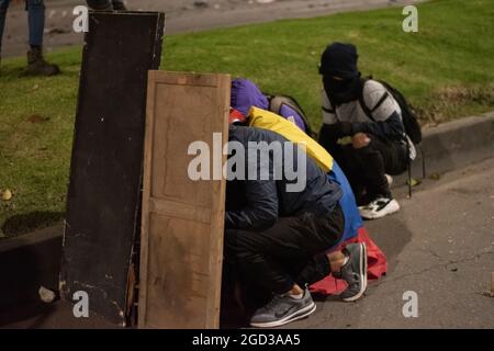 Bogota, Kolumbien, 09/08/2021, Demonstranten, die Schilde aus Holz und Metall verwendeten, um Wasser- und Tränengasbehälter zu bedecken, die von einem bewaffneten Lastwagen der kolumbianischen Bereitschaftspolizei während der Anti-Regierung geschossen wurden, was zu Zusammenstößen zwischen Demonstranten und der kolumbianischen Bereitschaftspolizei (ESMAD) inmitten der Räumung von Demonstranten führte, die während der letzten 3 in den Tibabuyes lagerten Monatelange regierungsfeindliche Proteste im Norden Bogotas, Kolumbien Stockfoto