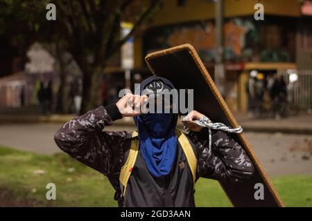 Bogota, Kolumbien, 09/08/2021, Demonstranten, die Schilde aus Holz und Metall verwendeten, um Wasser- und Tränengasbehälter zu bedecken, die von einem bewaffneten Lastwagen der kolumbianischen Bereitschaftspolizei während der Anti-Regierung geschossen wurden, was zu Zusammenstößen zwischen Demonstranten und der kolumbianischen Bereitschaftspolizei (ESMAD) inmitten der Räumung von Demonstranten führte, die während der letzten 3 in den Tibabuyes lagerten Monatelange regierungsfeindliche Proteste im Norden Bogotas, Kolumbien Stockfoto