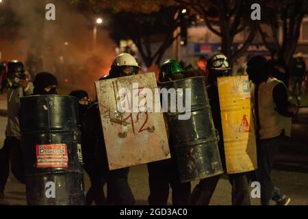 Bogota, Kolumbien, 09/08/2021, Demonstranten, die Schilde aus Holz und Metall verwendeten, um Wasser- und Tränengasbehälter zu bedecken, die von einem bewaffneten Lastwagen der kolumbianischen Bereitschaftspolizei während der Anti-Regierung geschossen wurden, was zu Zusammenstößen zwischen Demonstranten und der kolumbianischen Bereitschaftspolizei (ESMAD) inmitten der Räumung von Demonstranten führte, die während der letzten 3 in den Tibabuyes lagerten Monatelange regierungsfeindliche Proteste im Norden Bogotas, Kolumbien Stockfoto