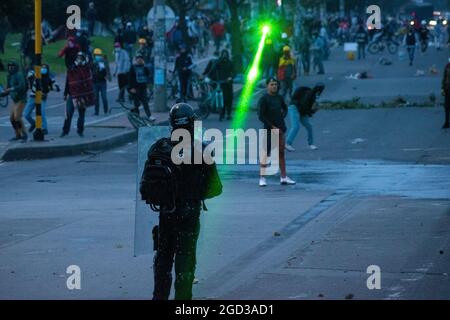 Bogota, Kolumbien, 09/08/2021, Demonstranten richten Laser auf kolumbianische Polizeibeamte während der Anti-Regierung, die in Zusammenstößen zwischen Demonstranten und der kolumbianischen Bereitschaftspolizei (ESMAD) endete, während die Demonstranten, die während der letzten 3 Monate regierungsfeindlicher Proteste im Norden Bogotas, Kolumbien, in den Tibabuyes lagerten, vertrieben wurden Stockfoto