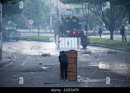 Bogota, Kolumbien, 09/08/2021, Demonstranten, die Holztüren aus Wasser- und Tränengaskanistern benutzten, die von einem gepanzerten Lastwagen der kolumbianischen Bereitschaftspolizei während der Anti-Regierung-Proteste angeschossen wurden, was in Zusammenstößen zwischen Demonstranten und der kolumbianischen Bereitschaftspolizei (ESMAD) endete, während die Demonstranten, die während der Anti-Regierungsproteste der letzten 3 Monate in den Tibabuyes lagerten, vertrieben wurden Im Norden Bogotas, Kolumbien Stockfoto