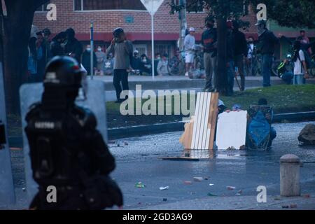 Bogota, Kolumbien, 09/08/2021, Demonstranten, die Holztüren aus Wasser- und Tränengaskanistern benutzten, die von einem gepanzerten Lastwagen der kolumbianischen Bereitschaftspolizei während der Anti-Regierung-Proteste angeschossen wurden, was in Zusammenstößen zwischen Demonstranten und der kolumbianischen Bereitschaftspolizei (ESMAD) endete, während die Demonstranten, die während der Anti-Regierungsproteste der letzten 3 Monate in den Tibabuyes lagerten, vertrieben wurden Im Norden Bogotas, Kolumbien Stockfoto