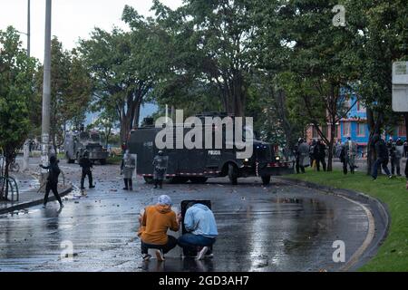 Bogota, Kolumbien, 09/08/2021, Demonstranten, die Holztüren aus Wasser- und Tränengaskanistern benutzten, die von einem gepanzerten Lastwagen der kolumbianischen Bereitschaftspolizei während der Anti-Regierung-Proteste angeschossen wurden, was in Zusammenstößen zwischen Demonstranten und der kolumbianischen Bereitschaftspolizei (ESMAD) endete, während die Demonstranten, die während der Anti-Regierungsproteste der letzten 3 Monate in den Tibabuyes lagerten, vertrieben wurden Im Norden Bogotas, Kolumbien Stockfoto