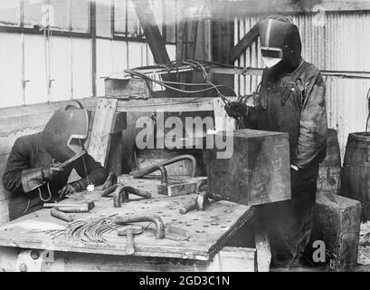 Schneiden mit Acetylenflamme, mit Masken & blauem Glas zum Schutz der Augen ca. zwischen 1909 und 1920 Stockfoto