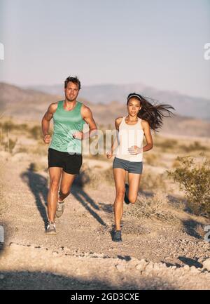 Die Läufer verbinden sich mit dem Langstreckenrennen Ultra Trail Run. Läufer und Sportlerin trainieren im Freien Kardio in der Landschaft des Sonnenuntergangs. Passform Stockfoto