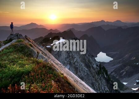 Kletterer am Vesper Peak bei Sonnenuntergang mit Blick auf Copper Lake, Big Four Mountain, Little Chief Peak und andere Berge, Central Cascade Mountains, Washin Stockfoto