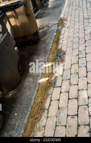 Brot wurde in einer Pfütze in einer Hintergasse hinterlassen. Stockfoto