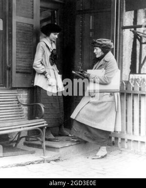 Frau, die eine andere Frau an der Tür des Hauses, ca. [Zwischen 1909 und 1932] Stockfoto