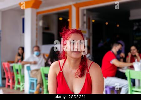 Porträt einer Latina-Frau mit roten Haaren, die in einem Café in einer kolumbianischen Stadt sitzt Stockfoto