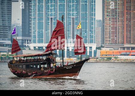 Die 'Aqua Luna', ein 2006 erbauter chinesischer Müll, passiert die Hochhäuser des Union Square in West Kowloon, während sie durch den Victoria Harbour fährt Stockfoto