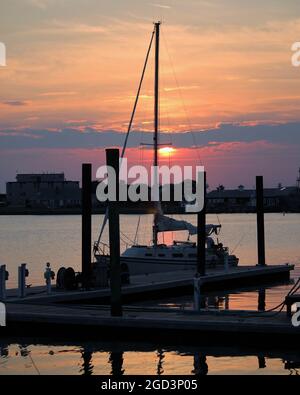 Ein einflügelges Segelboot ruht für den Abenduntergang Stockfoto