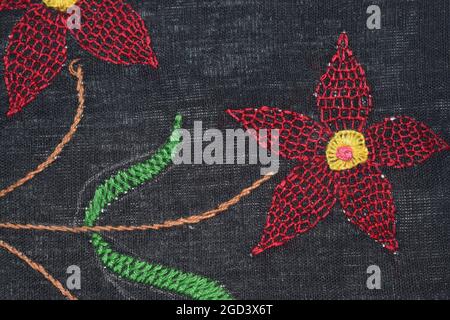 Honeycomb Stitch Blumen-Design auf schwarzem Stoff mit Fischgrätstich Stockfoto