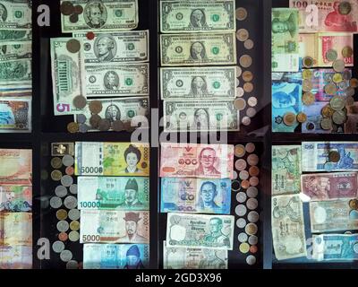 Draufsicht auf Banknoten und Münzen aus verschiedenen Ländern auf dem Glastisch gesammelt und ausgestellt. Sammlung vieler Banknoten aus verschiedenen Ländern Stockfoto